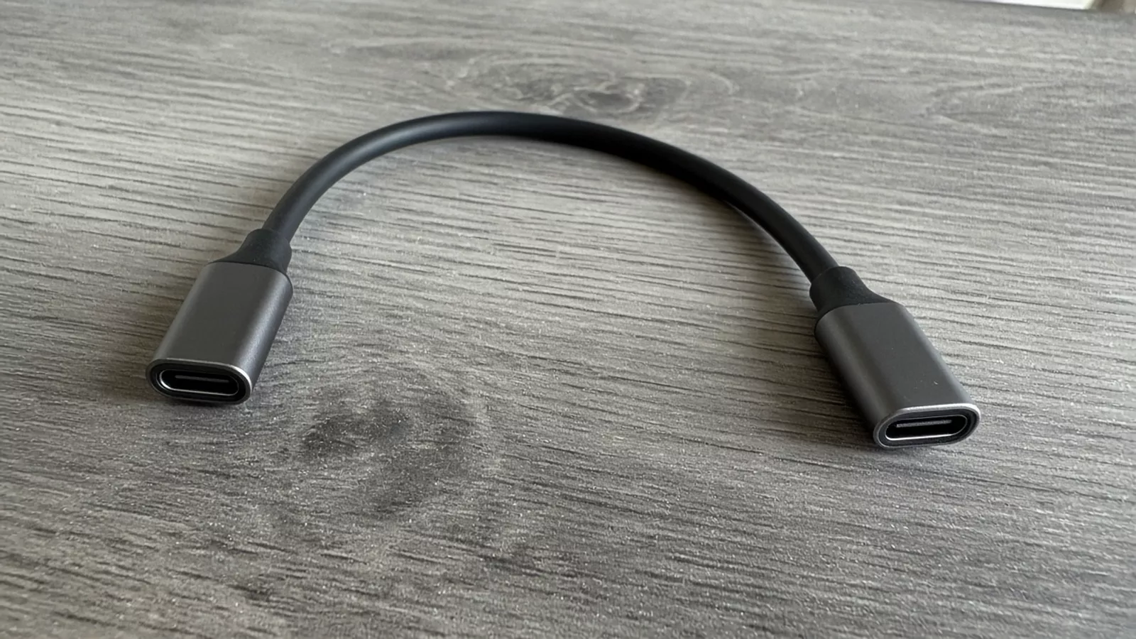 Both connectors of one unmarked cable on a gray table